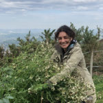 Photo d'Aurore, créatrice de KréAcor, au jardin des génies verts avec de la roquette dans les bras